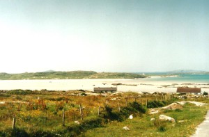 View from the peninsula on the lower, flat white sandy beach and the higher island far away...